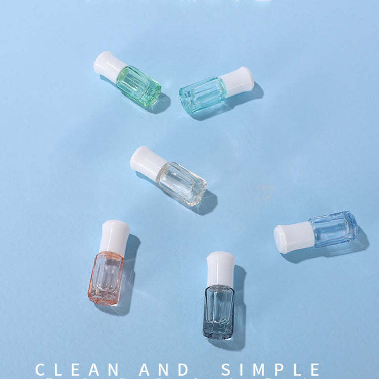 Colorful 3ml and 6ml glass essential oil roller bottles in various shades on a blue background.