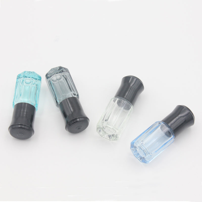 Colorful glass essential oil roller bottles in blue and clear, featuring stainless steel roll on balls.