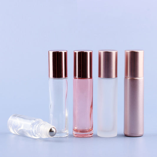 Assorted 5ml and 10ml roll-on glass perfume bottles with rose gold caps on a blue background.