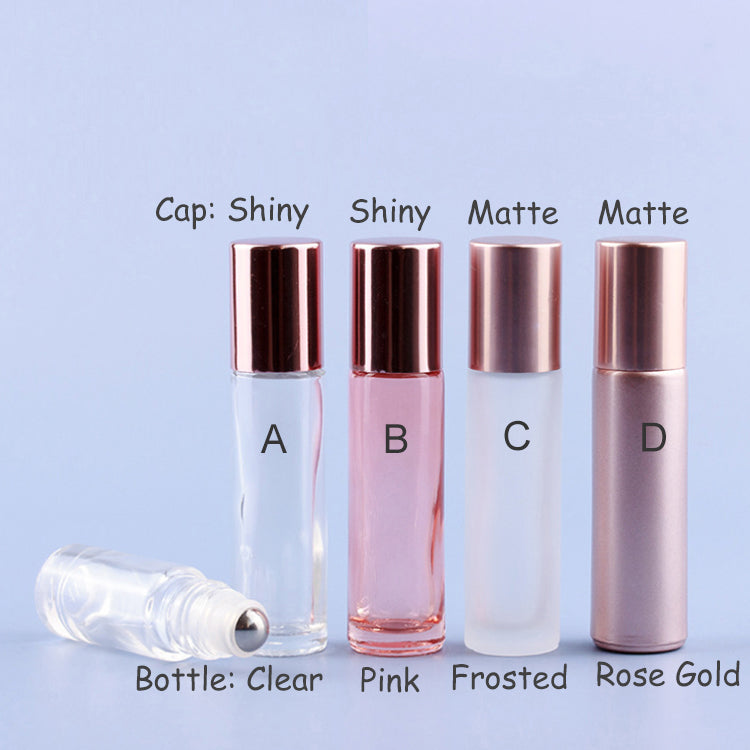 Different styles of roll-on perfume bottles: clear, pink, frosted, and rose gold, showcasing various cap finishes.