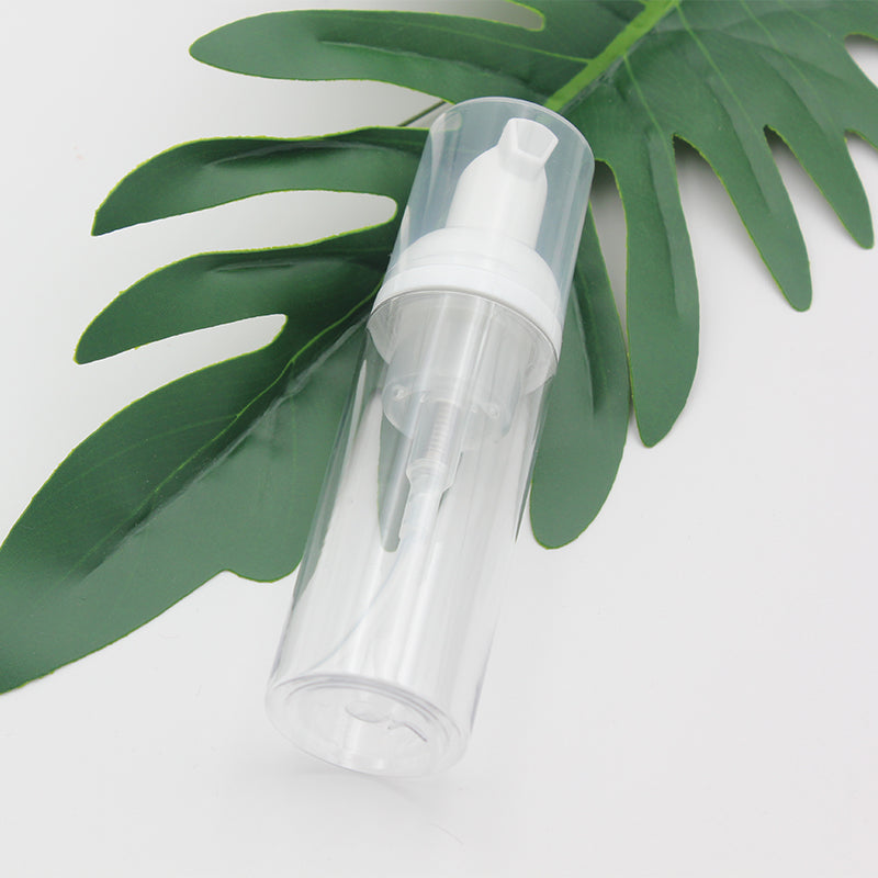 30ml plastic foam pump bottle with soap dispenser, clear design, positioned on green leaf background.